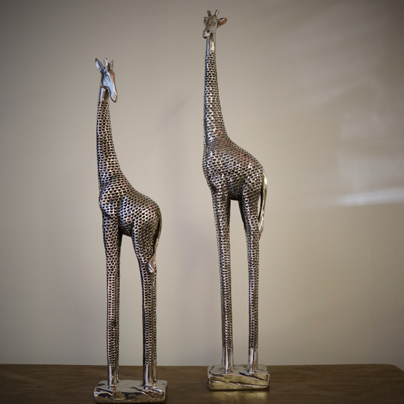 A set of small and large decorative giraffes in metallic silver finish