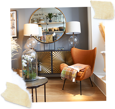 gold starburst sideboard dressed with lamps and an orange winged occasional chair