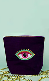 navy blue velvet makeup bag with a beaded eye pattern