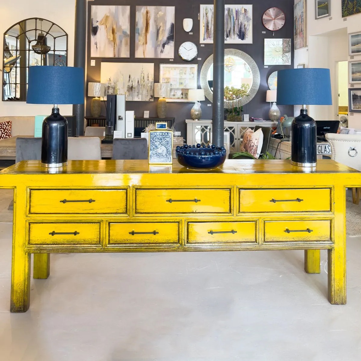 yellow painted wooden sideboard with blue decorative lamps on top