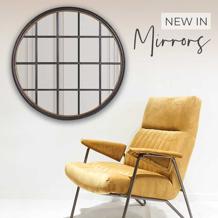 A black circular grid mirror hanging on wall above a mustard velvet lounge chair