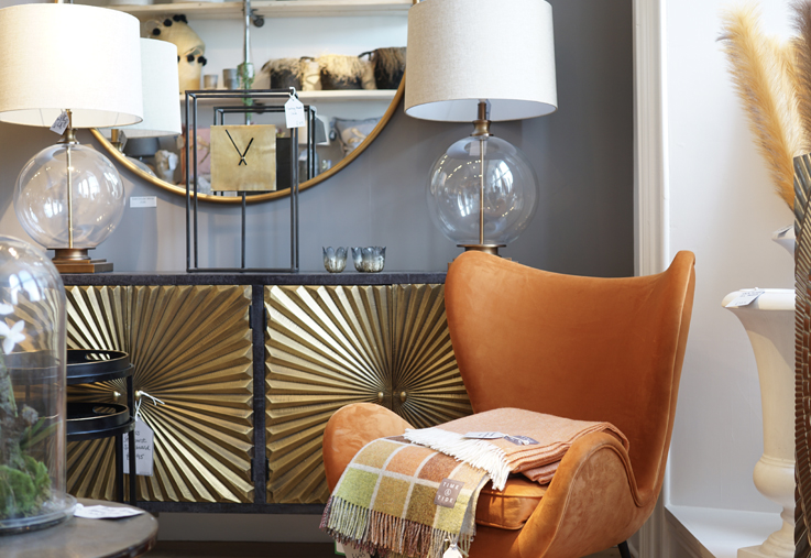 Gold starburst unit with orange wing chair and large mirror