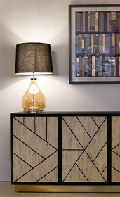 geometric design sideboard with lamp on top and canvas with book print on wall 