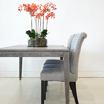 Grey Oak Dining Table with 4 dining chairs and an orchid on tabletop