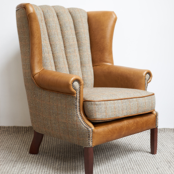a harris tweed arm chair in gamekeeper tweed with brown leather details