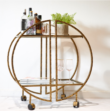 round gold bar trolley with bottles and glasses
