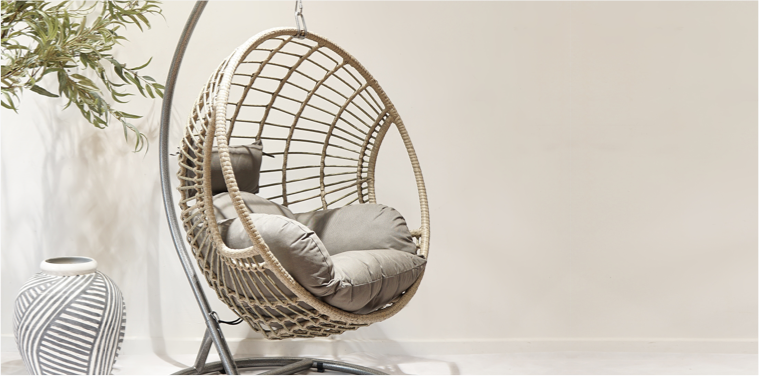 round wicker hanging chair with grey cushion pads and floor vase