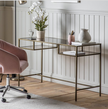 glass and iron desk with pink velvet office chair in front