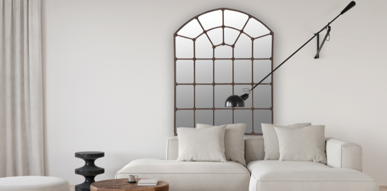 Large iron arch mirror with windowpane detail on wall above sofa