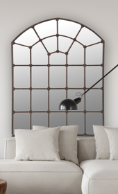 large iron arch mirror hung above sofa