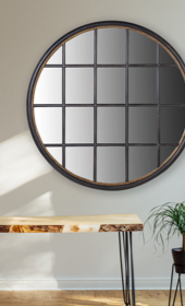 black round wood pane mirror hung above bench