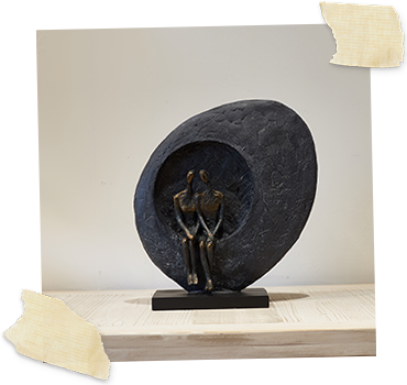 bronze round sculpture with couple sitting in center