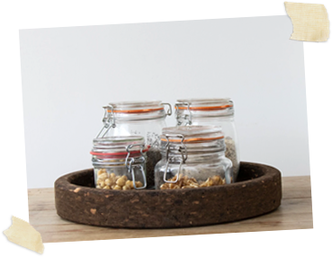 four glass jars sitting within a smoked cork table mat
