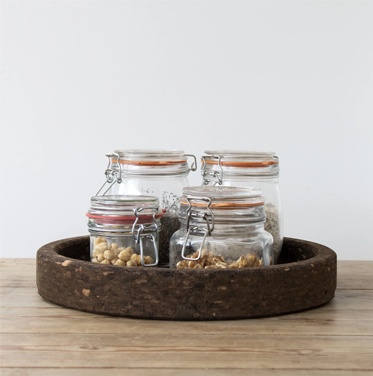 4 glass storage jars on smoked cork tray