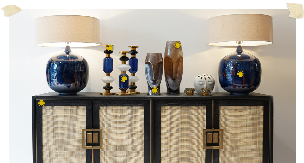 black and rattan 4 door sideboard dressed with large blue lamps and blue candlesticks