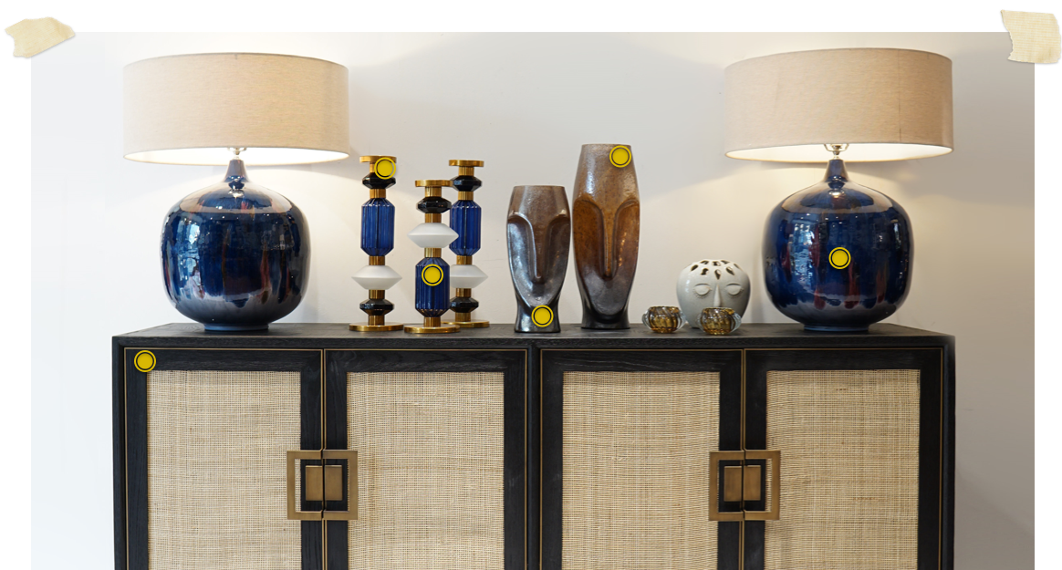 black and rattan 4 door sideboard dressed with large blue lamps and blue candlesticks