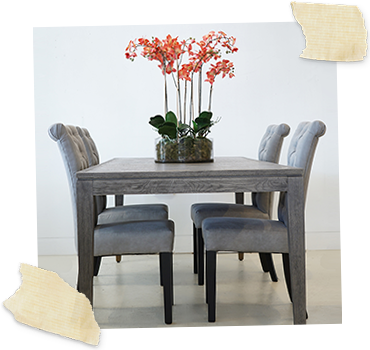 Oak wood rectangular dining table with 4 grey dining chairs and an orchid to top
