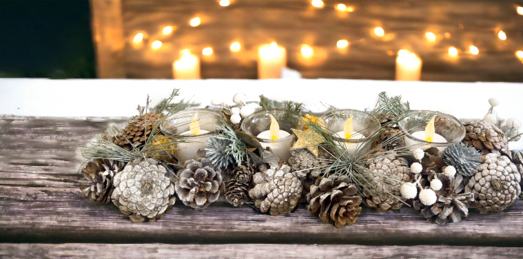 a pinecone candleholder sitting on a wooden bench with candles in background