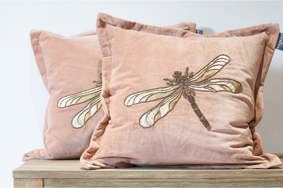two blush velvet cushions with beaded dragonfly to centre on top of bench
